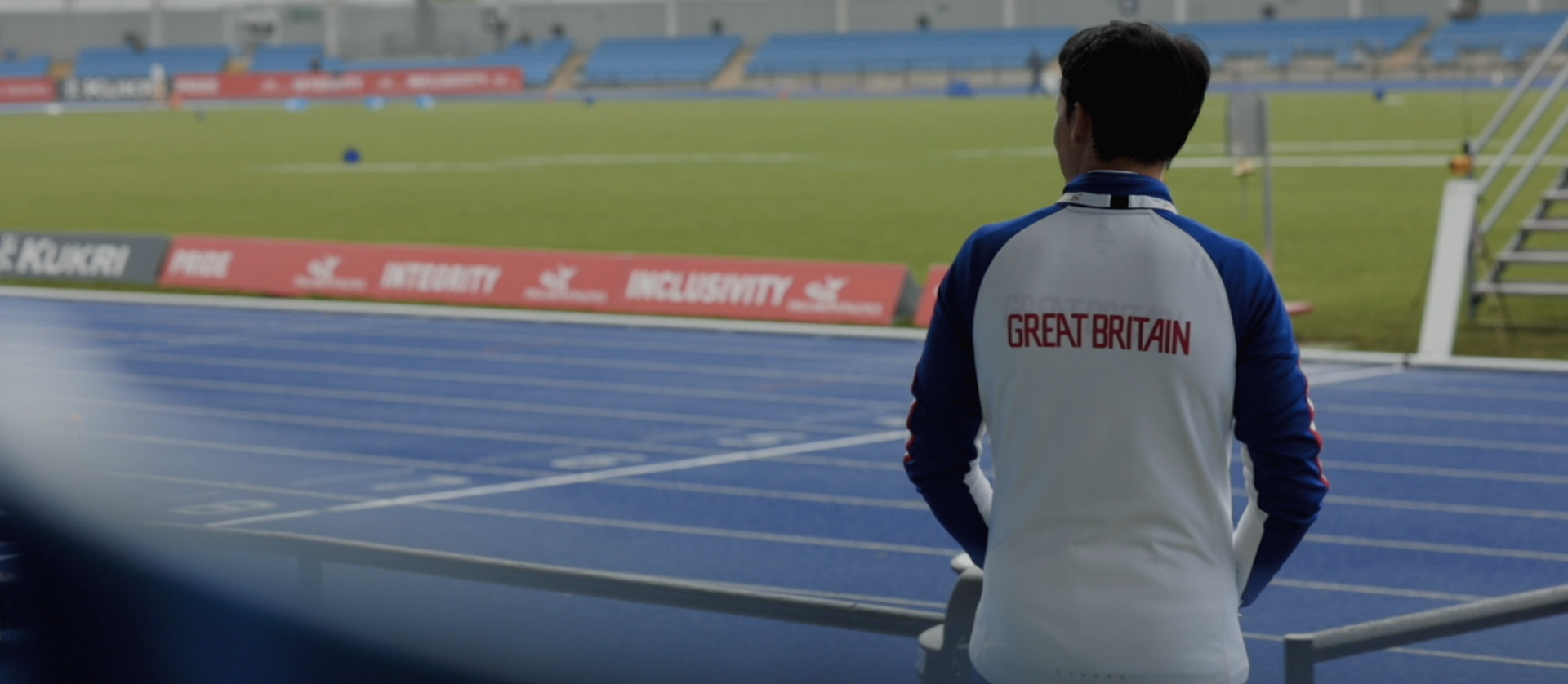 Man stares out at pitch at England Athletics event